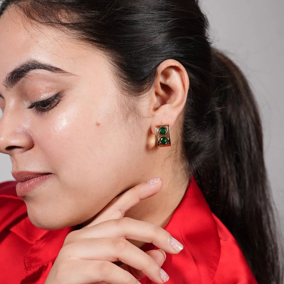 Bhavya wearing Bold Emerald Double Stone Gold Huggie Hoop Earrings